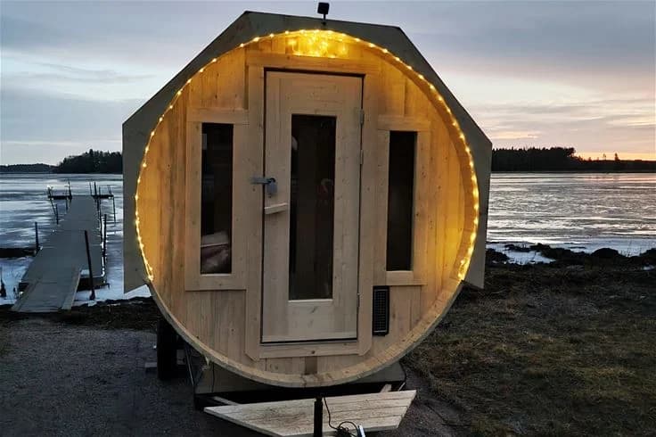 Bild på en träbyggnad med stockkonstruktion på Strandstuvikens havsbad & camping. Byggnaden består av träplankor med mörk träbehandling och ger en rustik känsla som smälter in i den naturnära omgivningen.