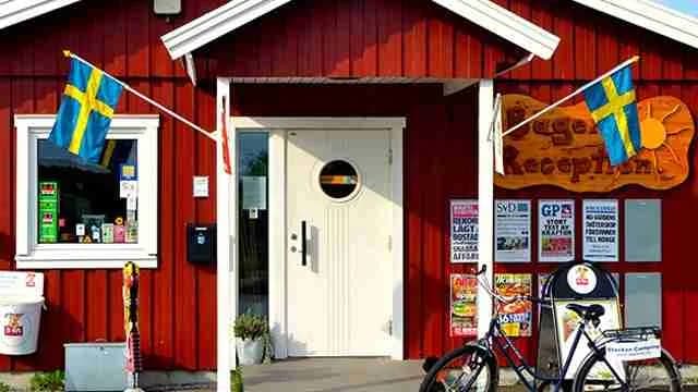 En träddörr på en campingplats, omgiven av grönska.