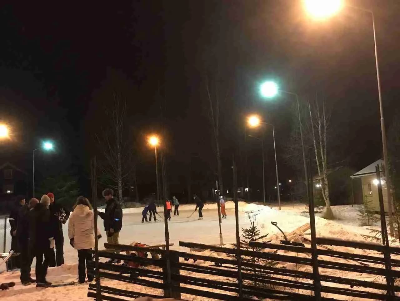 En nattbild av Yttermalungs camping & stugby under vintern. Gatlyktor belyser snötäckt mark och omgivning, vilket skapar en lugn och fridfull stämning.