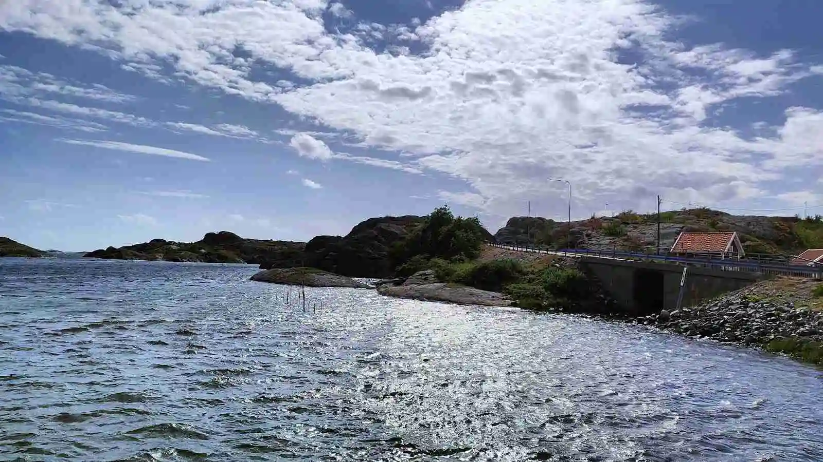 Vy över en kustnära plats vid Mossholmen med klippor och öppet vatten i bakgrunden.