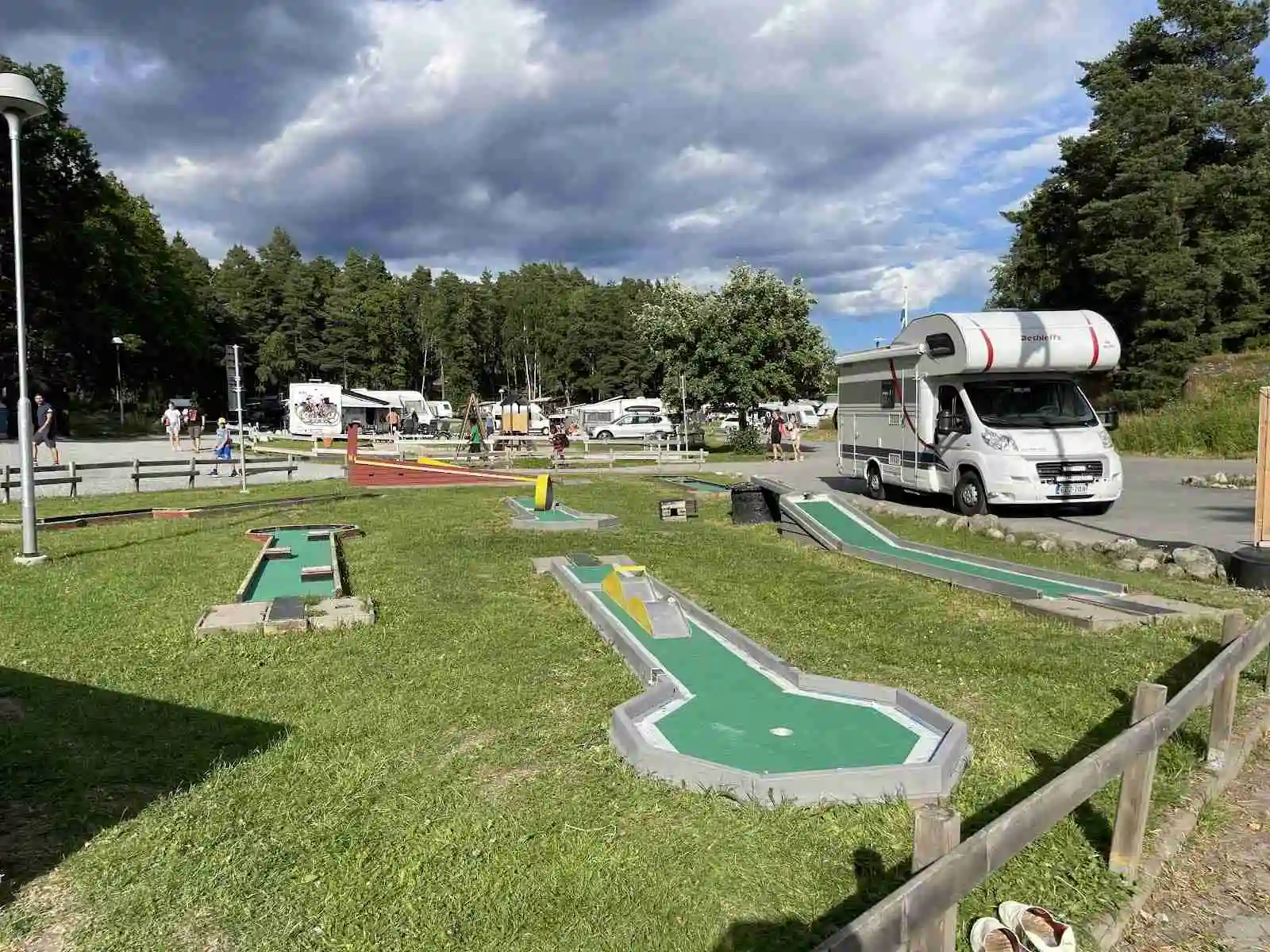 En bild av Waxholms camping, med husvagnar uppställda på en grönskande campingplats omgiven av träd och natur.