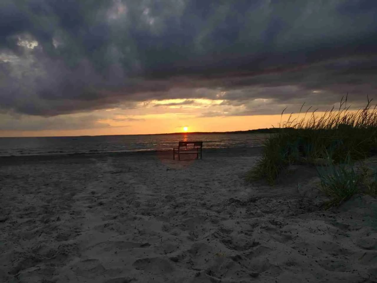 En bild av himlen under skymning vid Vallersvik Camping and Hostel, med färgglada moln och en horisont som glöder i orange och rött ljus.