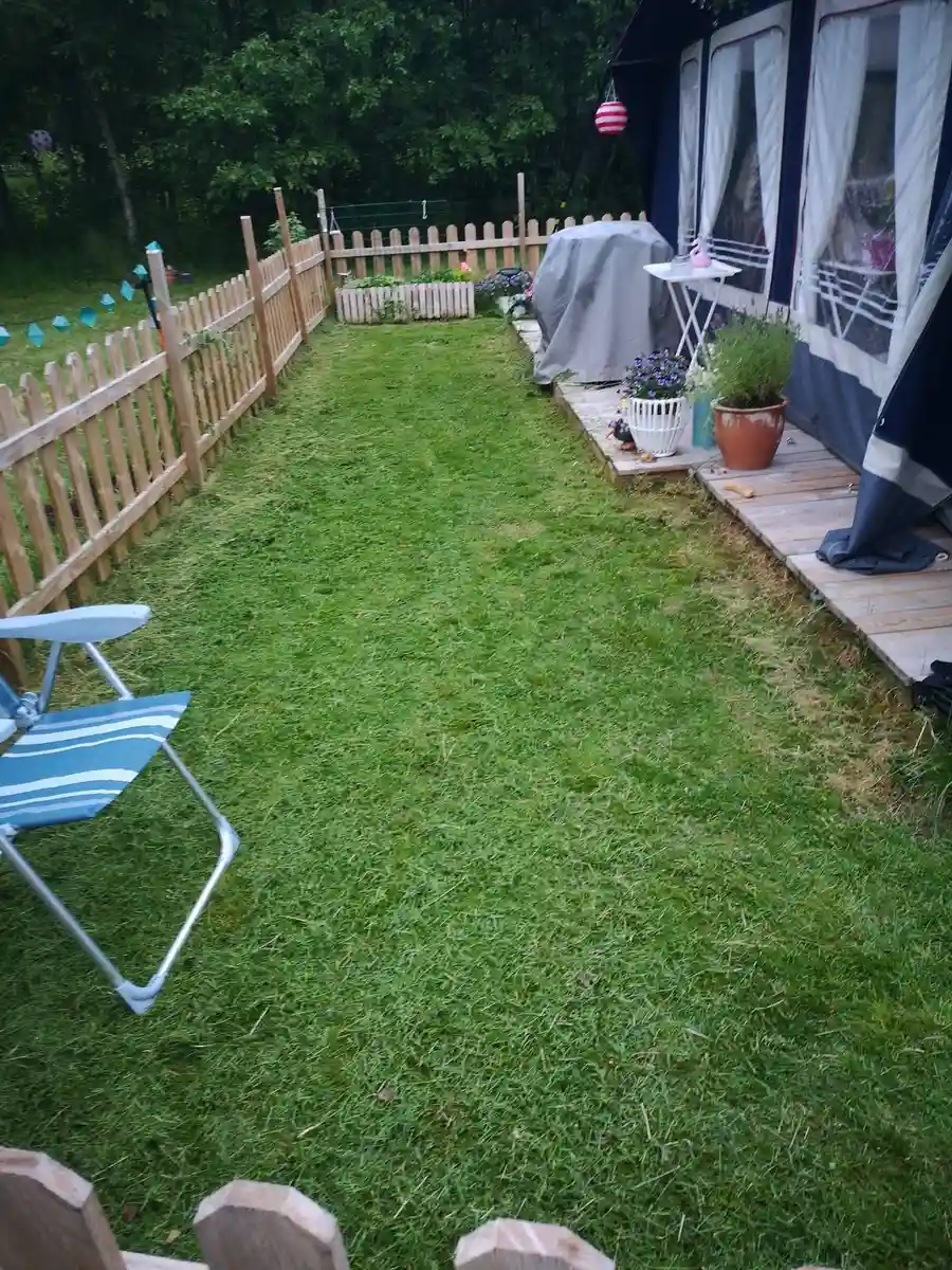 En grönskande campingplats med gräsytor, utemöbler och välskött landskap, på Norrmjöle camping.