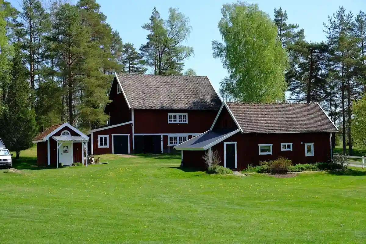 En liten stuga i ett lantligt område, omgiven av gräs och träd.
