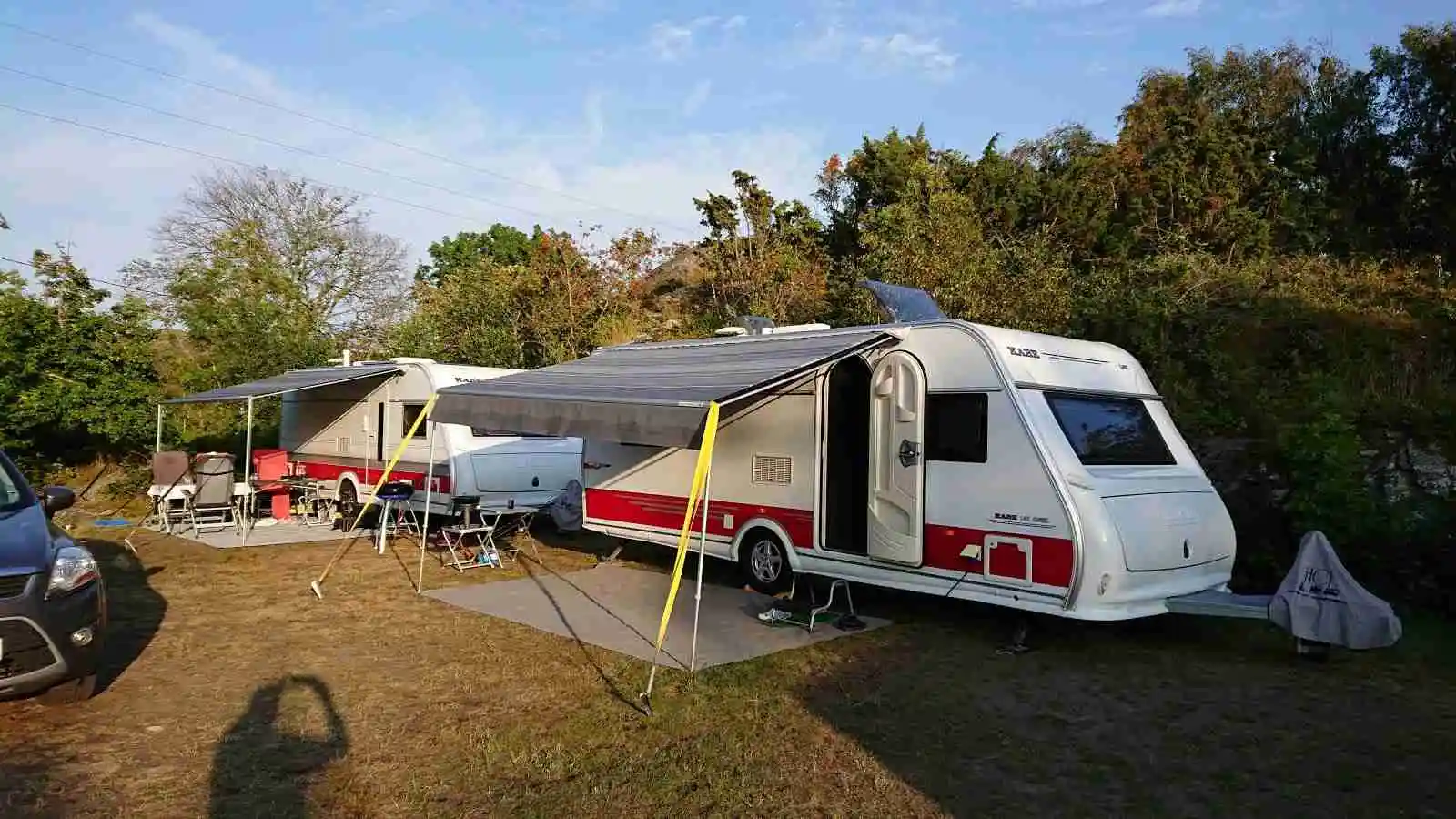 En parkeringsplats med flera husvagnar och campingfordon vid Hav & Logi Skärhamn, omgivna av natur och friluftsliv.