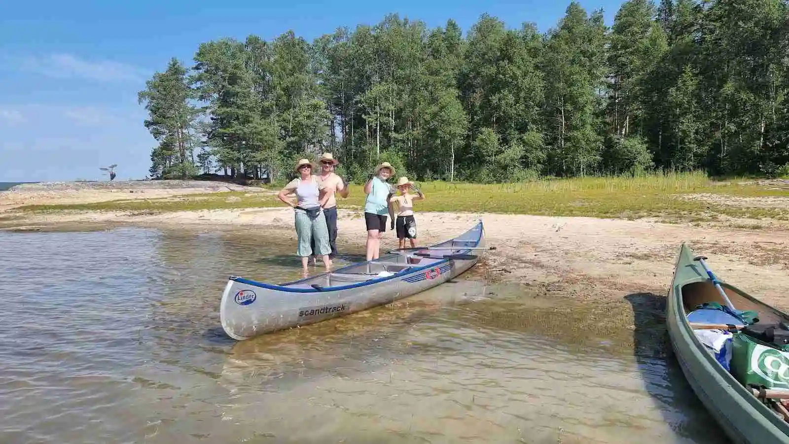 En man paddlar en kanot på en lugn sjö omgiven av grönskande skog, en typisk ögonblicksbild av rekreation vid älvsbyn camping & canoe.