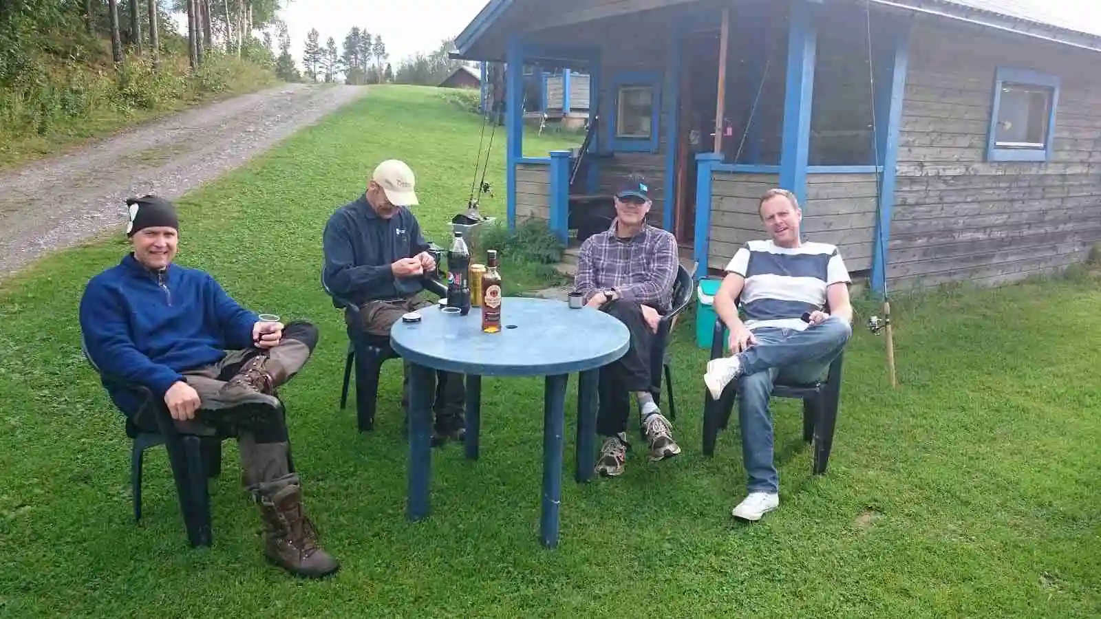 En grönskande trädgård på Kvissleströmmens fiskecamping, med utomhusmöbler för avkoppling och rekreation.