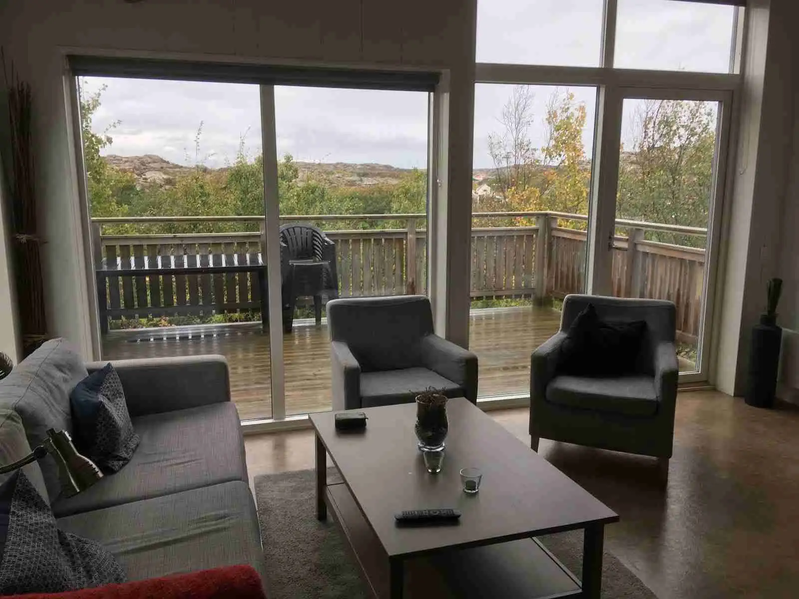 Bild av ett modernt och inbjudande inrett rum på Hav & Logi Skärhamn. Rummet har trägolv, möbler i trä och bekväma stolar, vilket skapar en varm och hemtrevlig atmosfär som lockar besökare att koppla av.