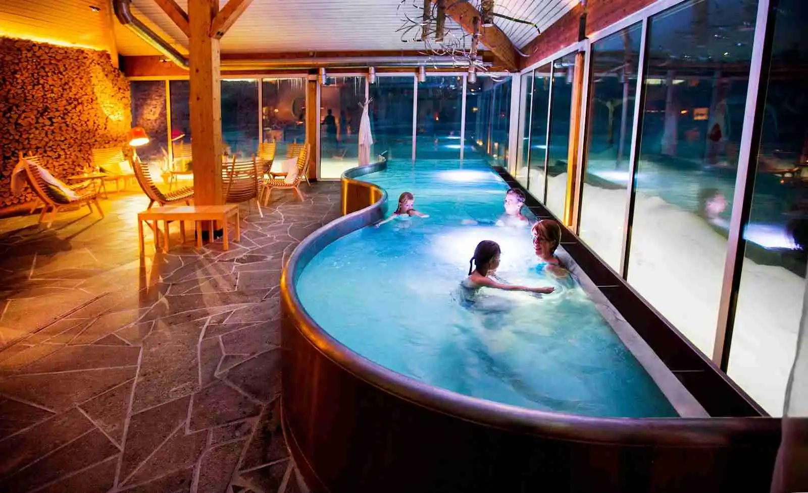 En bild av Camp Ripan, ett eko-hotell och semesteranläggning, med en inbjudande swimmingpool omgiven av naturskön omgivning, perfekt för avkoppling och bad.