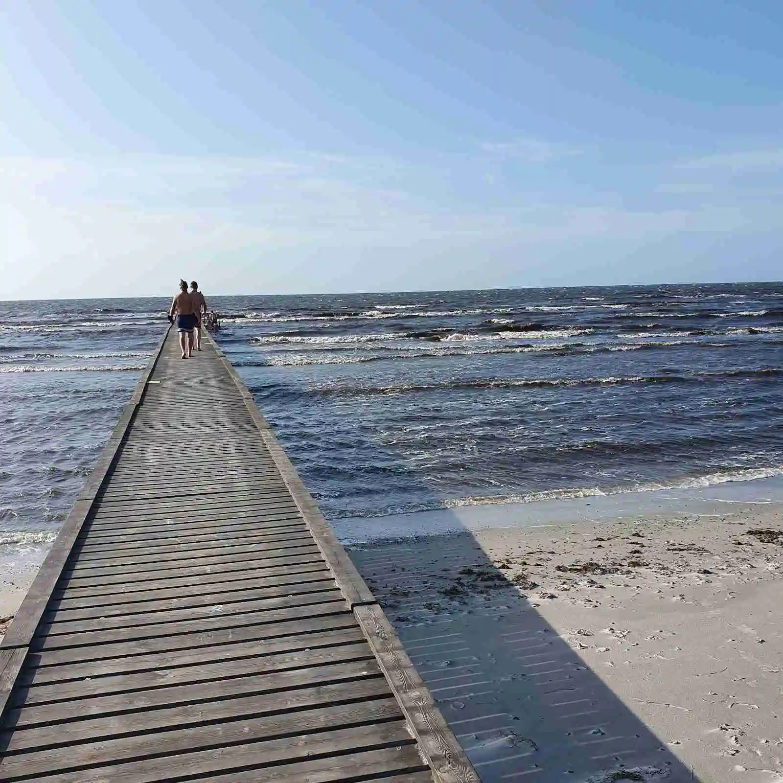 En vidsträckt strand vid Bingsmarkens camping med havet i bakgrunden, vågor som rullar in mot kusten och en öppen horisont.