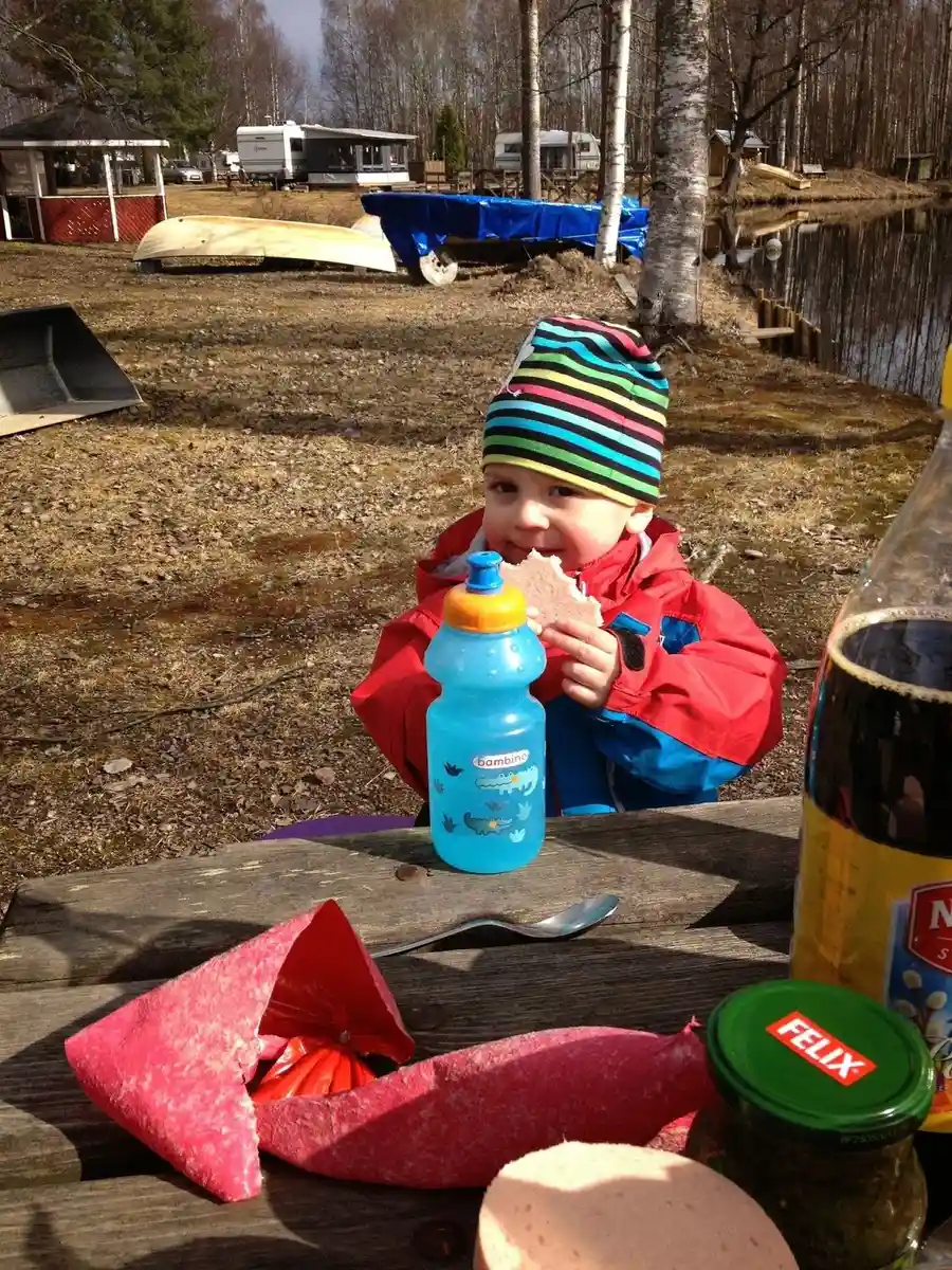 En liten barnlek med en plastflaska, omgiven av lekfulla barntillbehör på Camp Kungsgården.