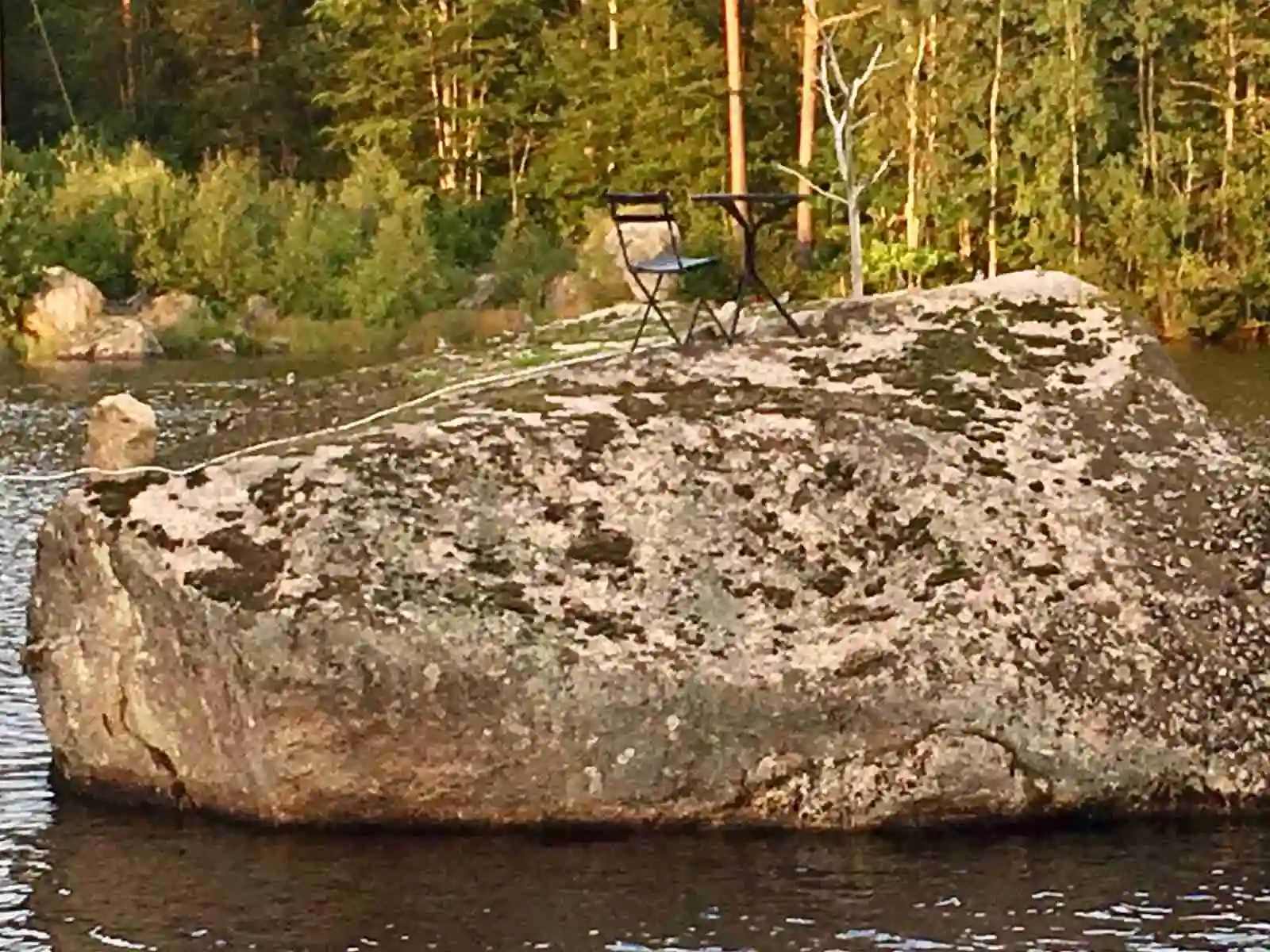 En storslagen vy över en bergig flodmiljö vid Hjorthalan Camping, med klippblock och stenformationer som skapar ett robust landskap kring det strömmande vattnet.