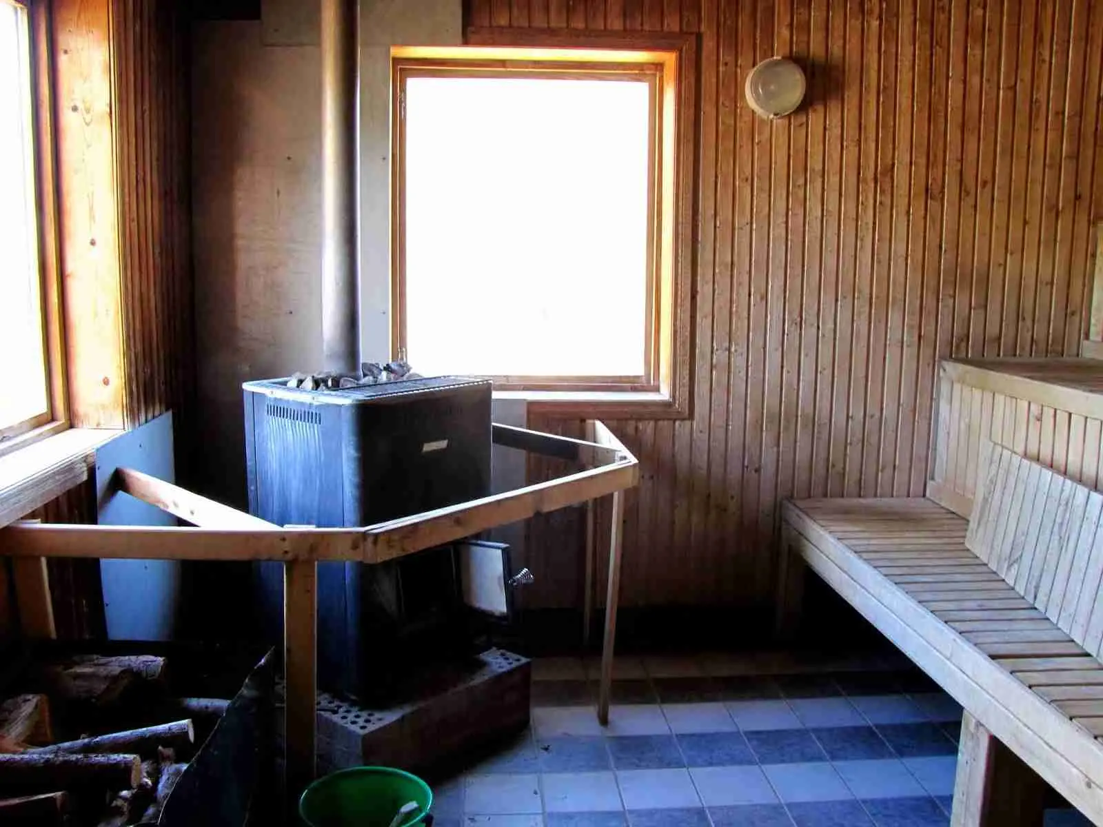 En interiörbild av Arkösunds camping som visar ett träbelagt golv och tak i ljust trä med dagsljus som strömmar in. Golvet och taket har en varm ton av lackat trä, vilket skapar en inbjudande och naturlig atmosfär.