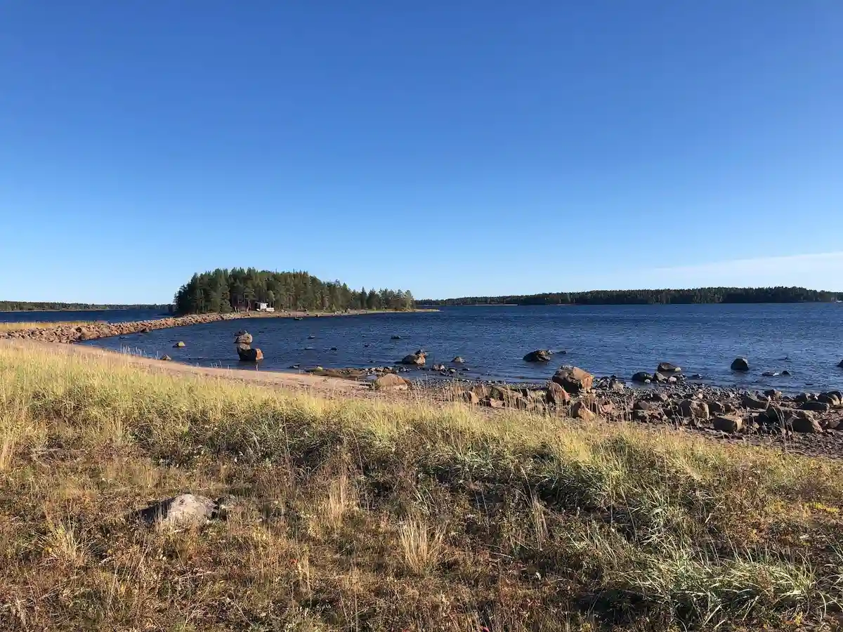 Bild av Rörbäcks camping och havsbad med kustnära landformer. En kropp av vatten sträcker sig mot horisonten, omgiven av klippiga kuster och strandkanter.
