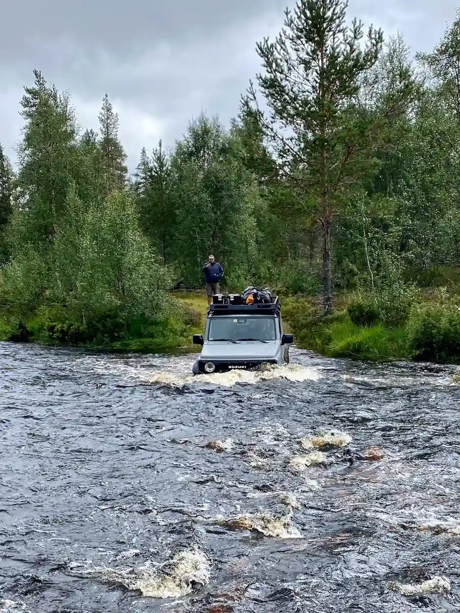 En terrängbil från Ford navigerar genom en ström i ett våtmarksområde, omgiven av äventyrlig och frodig natur.