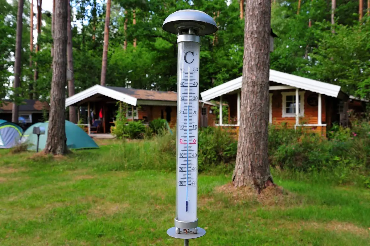 En campingplats med gröna omgivningar och en park. Ett mätinstrument syns i förgrunden.