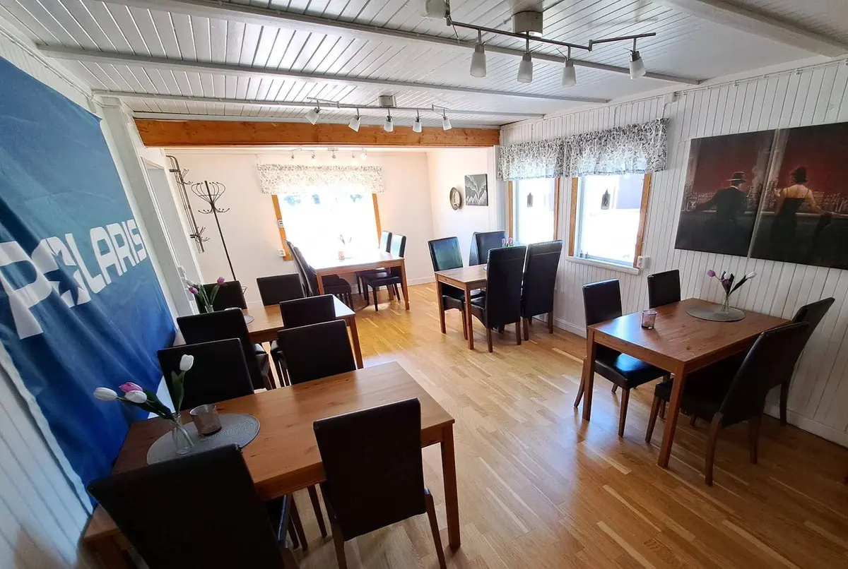 Ett träinspirerat rum i Lillhärdals camping med trämöbler, inklusive ett bord och stolar, samt ett golv av trä eller laminerat trä som bidrar till en varm och inbjudande atmosfär.