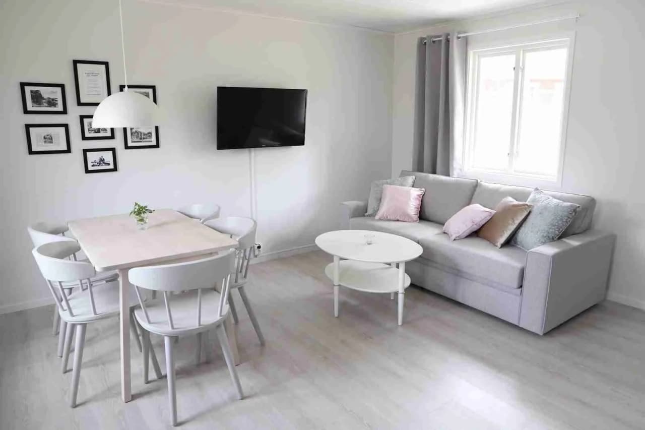 Interiörbild från Tingsryd Resort med bekvämt möblemang, inklusive en soffa och ett bord, i ett smakfullt inrett vardagsrum med stilren belysning och trägolv.