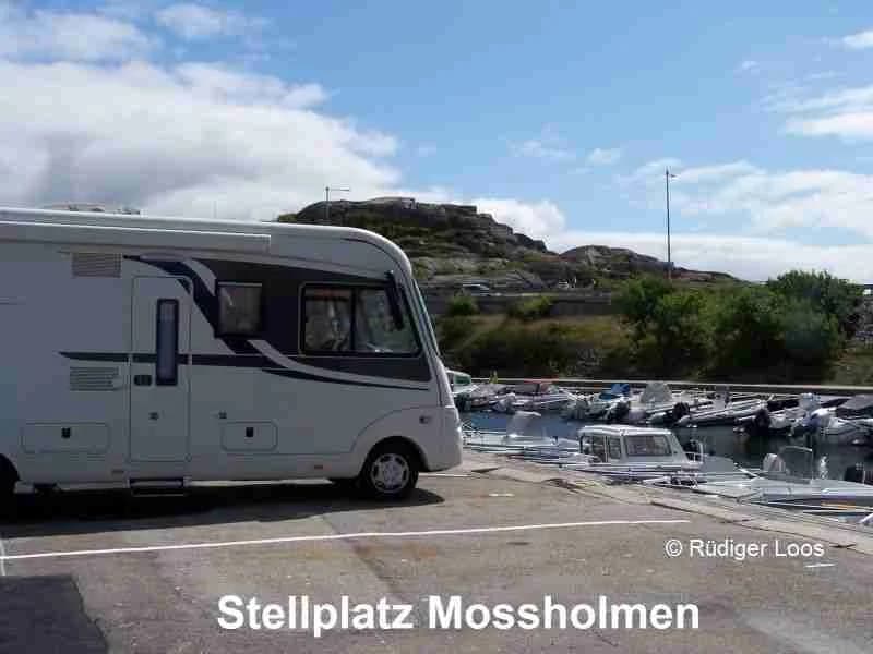 En husbil och en husvagn parkerade på en öppen plats vid Wohnmobilstellplatz Mossholmen.