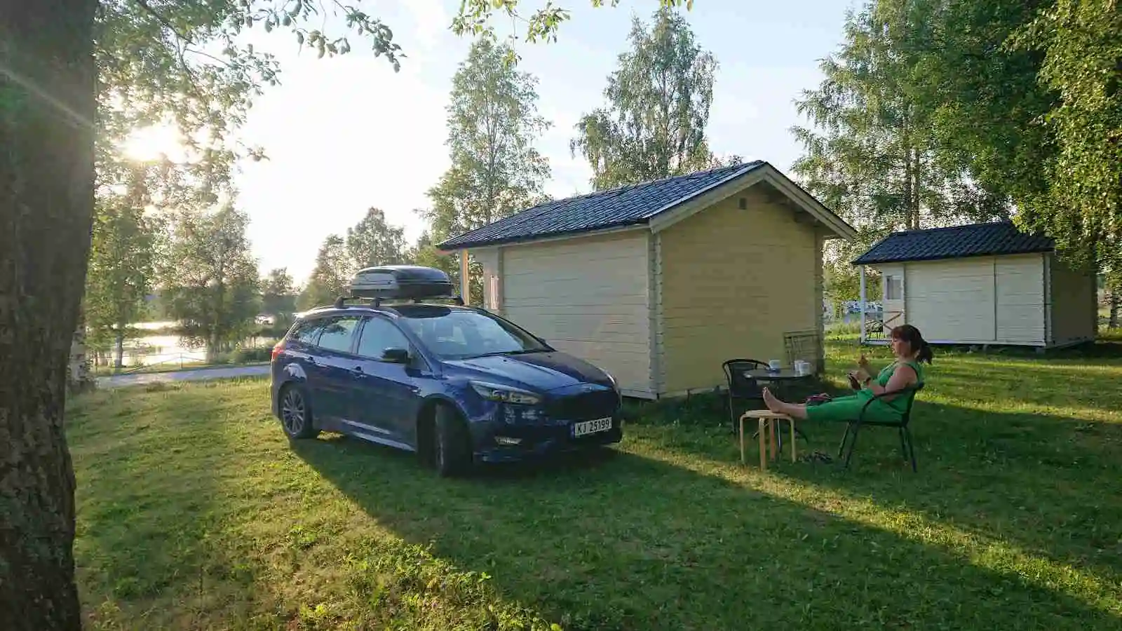 Bild av en parkerad familjebil vid Krokomvikens camping, med bakluckan öppen och omgivande grönytor.