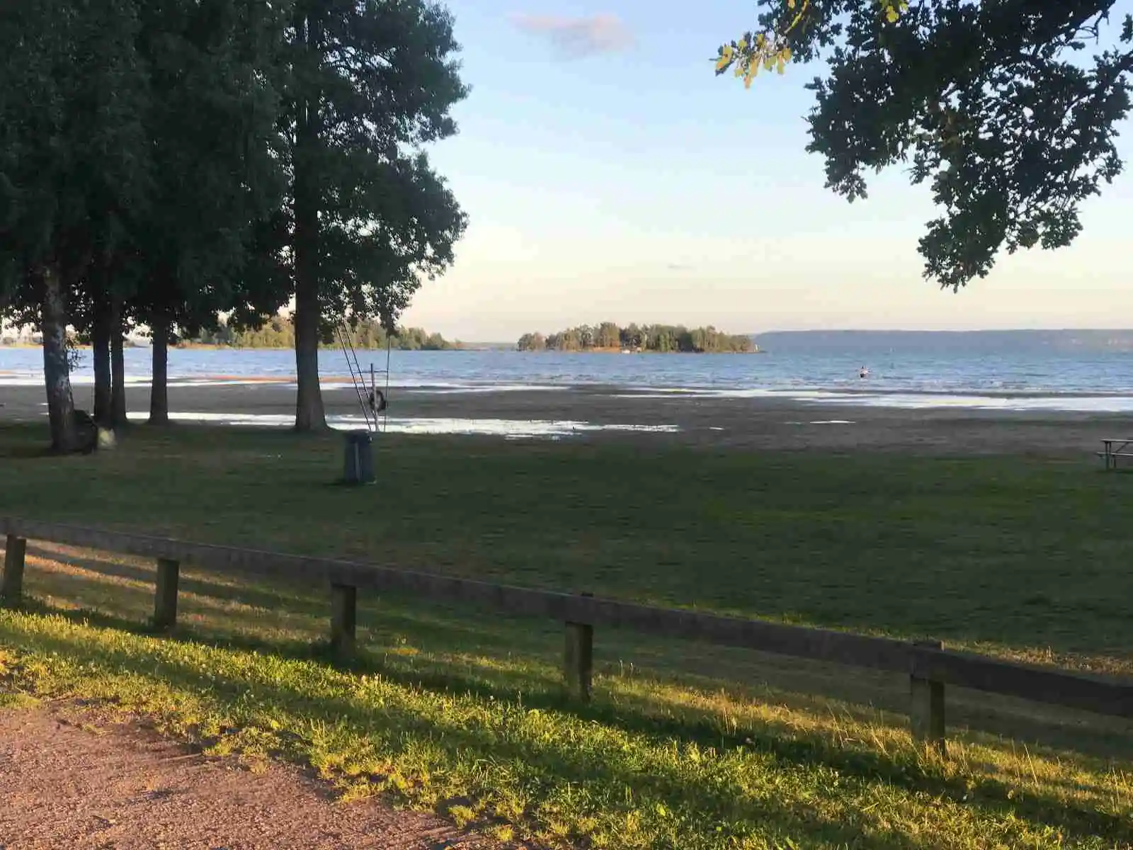 En grönskande campingplats med frodig vegetation, där träd och gräs breder ut sig i ett naturskönt och öppet landskap på Sikhalls camping.