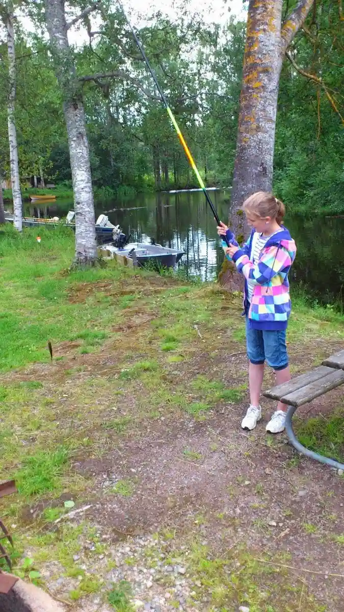 En ung pojke kastar sitt metspö i en sjö vid Camp Kungsgården, en populär plats för fritidsfiske och avkoppling i naturen.