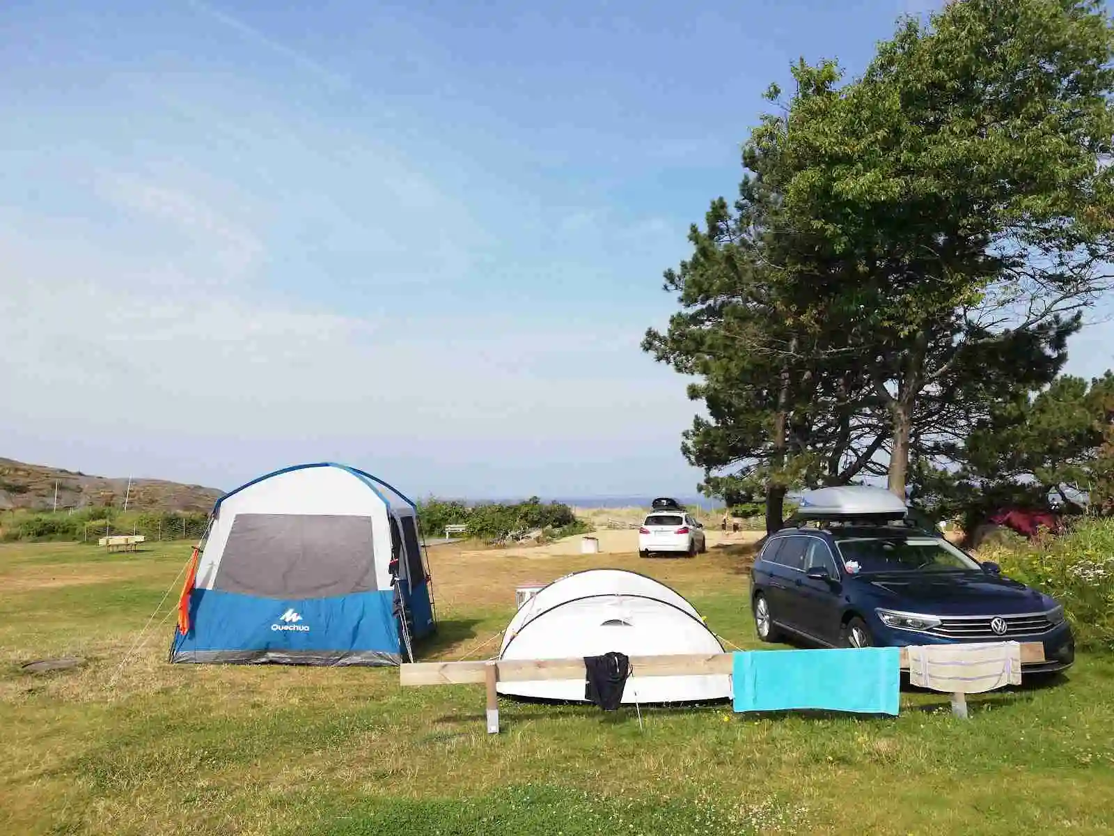 Bild på ett tält och flera campingutrustningar uppställda på Vallersvik Camping and Hostel. I bakgrunden syns en sportig SUV med ett takräcke, redo för campingäventyret.