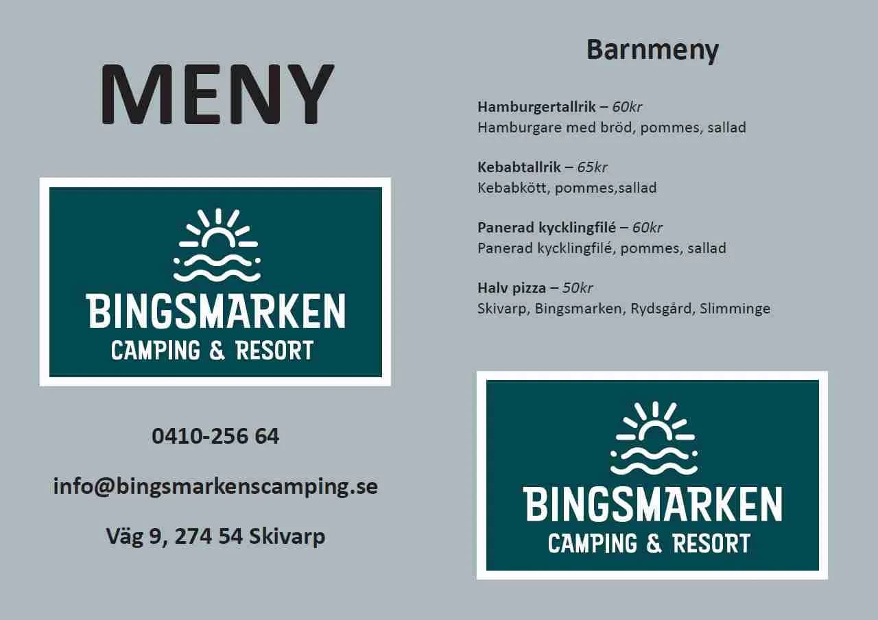 En bild av Bingsmarkens camping, där en färgglad informationsskylt lockar besökare med bilder av strandaktiviteter och campingfaciliteter i en idyllisk miljö.